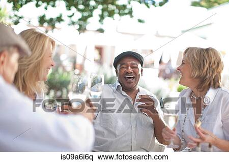 Stock Photography - Older friends having wine together. Fotosearch