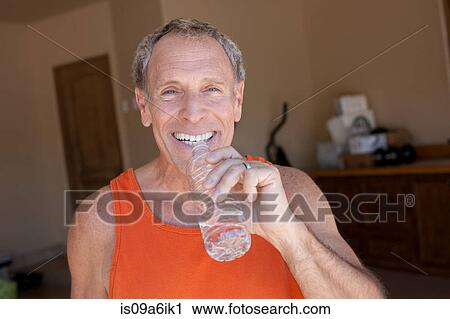 Stock Image - Older man drinking water bottle. Fotosearch