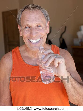 Stock Image - Older man drinking water bottle. Fotosearch