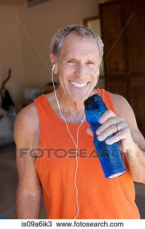 Stock Image - Older man drinking water bottle. Fotosearch