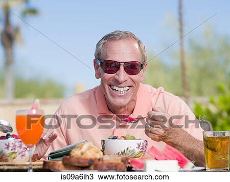 Older man having breakfast outdoors View Large Photo Image Stock Image - Older man having breakfast outdoors. Fotosearch