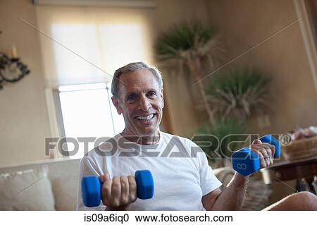 Older man lifting weights at home View Large Photo Image Stock Image - Older man lifting weights at home. Fotosearch