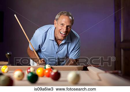Stock Image - Older man playing pool. Fotosearch
