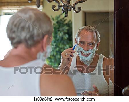 Older man shaving his face in bathroom View Large Photo Image Stock Image - Older man shaving his face in bathroom. Fotosearch