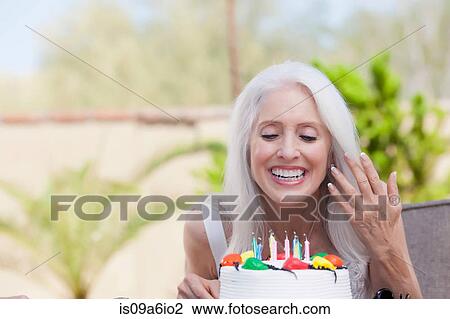 Older woman blowing birthday candles View Large Photo Image Stock Image - Older woman blowing birthday candles. Fotosearch