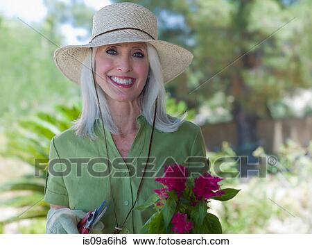Stock Photo - Older woman gardening outdoors. Fotosearch