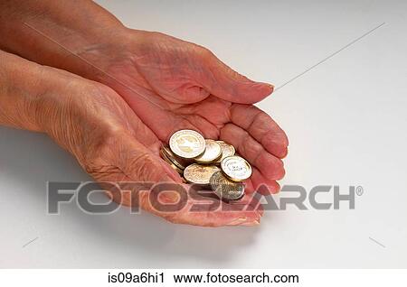 Stock Image - Older woman holding Euro coins. Fotosearch