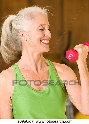 Older woman lifting weights at home View Large Photo Image Stock Photo - Older woman lifting weights at home. Fotosearch