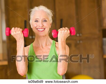 Stock Photo - Older woman lifting weights at home. Fotosearch
