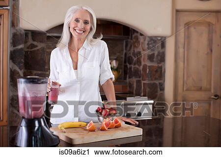 Older woman making smoothie in kitchen View Large Photo Image Stock Image - Older woman making smoothie in kitchen. Fotosearch