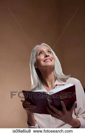 Stock Photo - Older woman reading bible. Fotosearch