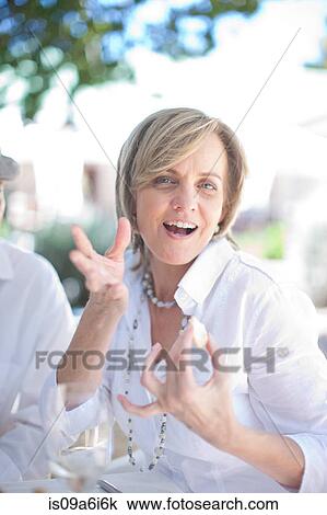 Older woman talking at table outdoors View Large Photo Image Stock Image - Older woman talking at table outdoors. Fotosearch