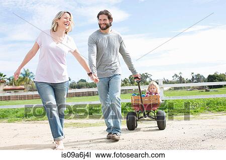 Parents pulling son in wagon View Large Photo Image Stock Image - Parents pulling son in wagon. Fotosearch