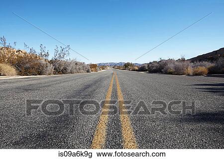 Stock Image - Paved road in rural landscape. Fotosearch