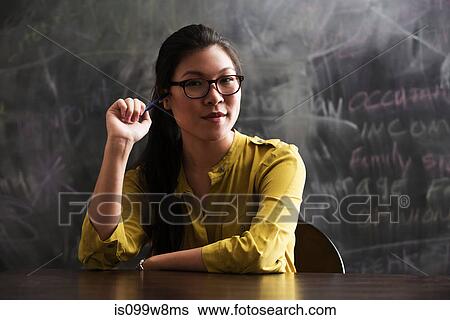 Portrait of woman in front of blackboard View Large Photo Image Stock Photograph - Portrait of woman in front of blackboard. Fotosearch
