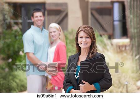 Realtor with couple outside home View Large Photo Image Stock Image - Realtor with couple outside home. Fotosearch