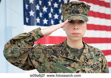 Stock Image - Servicewoman in camouflage by US flag. Fotosearch