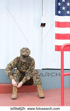 Stock Image - Servicewoman in camouflage by US flag. Fotosearch