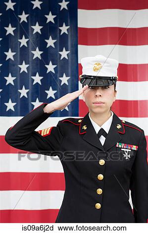 Stock Image - Servicewoman in dress blues by US flag. Fotosearch