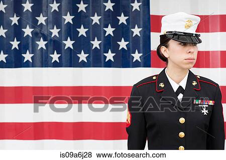 Stock Photo - Servicewoman in dress blues by US flag. Fotosearch