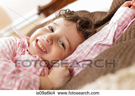 Picture - Smiling boy laying on bed. Fotosearch