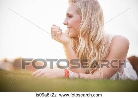 Smiling woman laying in grass View Large Photo Image Stock Photo - Smiling woman laying in grass. Fotosearch