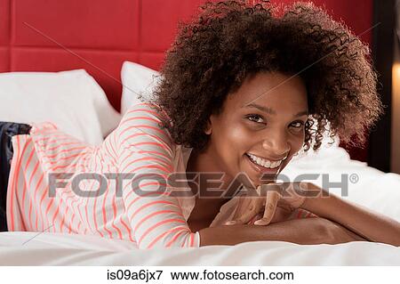 Smiling woman laying on bed View Large Photo Image Stock Photo - Smiling woman laying on bed. Fotosearch