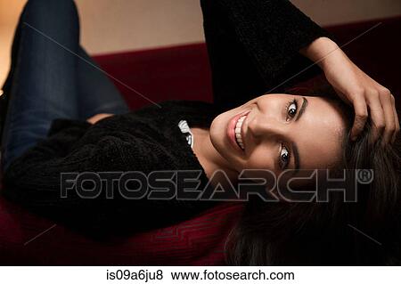 Smiling woman laying on sofa View Large Photo Image Stock Photo - Smiling woman laying on sofa. Fotosearch
