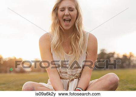 Smiling woman shouting in field View Large Photo Image Stock Photo - Smiling woman shouting in field. Fotosearch