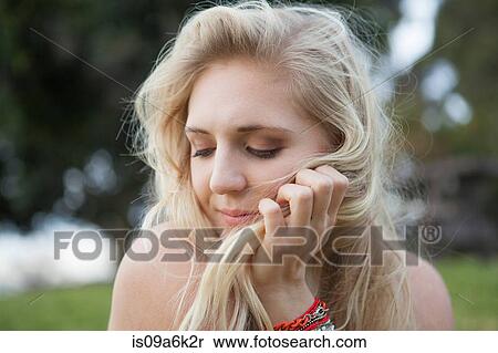 Stock Photography - Smiling woman sitting in field. Fotosearch