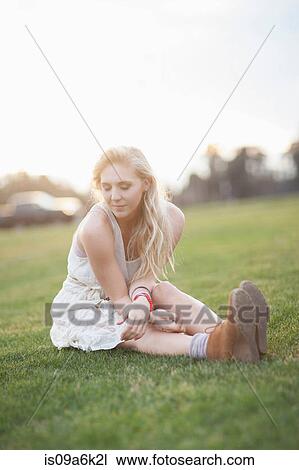 Smiling woman sitting in grass View Large Photo Image Stock Image - Smiling woman sitting in grass. Fotosearch