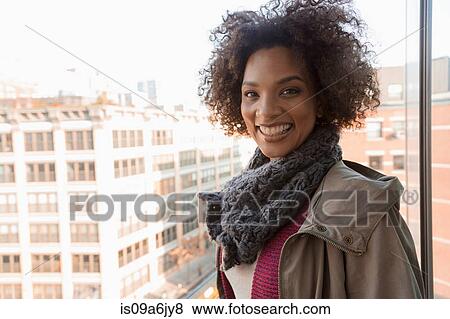 Smiling woman standing at window View Large Photo Image Stock Photo - Smiling woman standing at window. Fotosearch