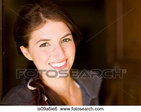 Stock Photograph - Smiling woman standing in doorway. Fotosearch
