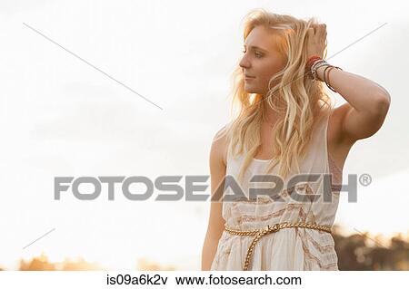 Smiling woman standing in field View Large Photo Image Stock Photo - Smiling woman standing in field. Fotosearch