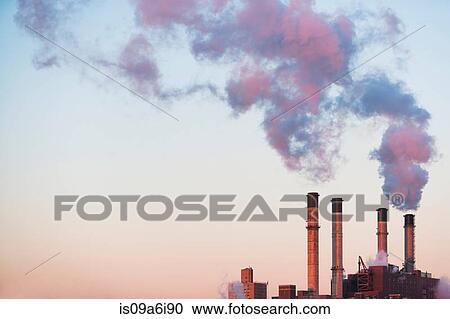 Stock Image - Smoke billowing from industrial plant. Fotosearch