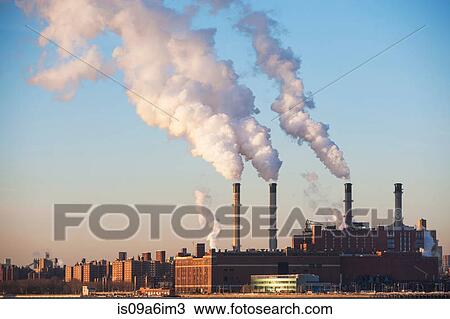 Stock Image - Smoke billowing from industrial plant. Fotosearch