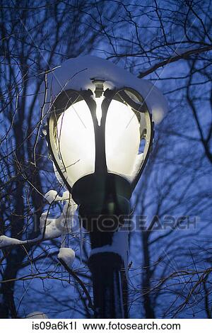 Stock Image - Snow covered streetlight in park. Fotosearch