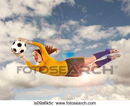Stock Image - Soccer player catching ball in air. Fotosearch