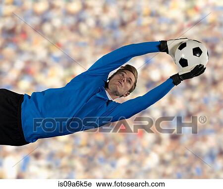 Stock Image - Soccer player catching ball in air. Fotosearch