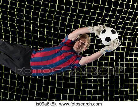 Stock Image - Soccer player catching ball in air. Fotosearch