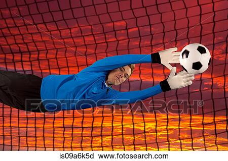 Stock Image - Soccer player deflecting ball in air. Fotosearch