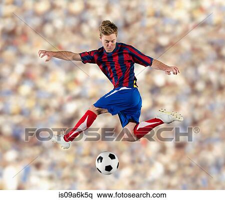 Stock Photography - Soccer player kicking ball in air. Fotosearch