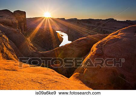 Stock Photo - Sun rising over canyon rock formations. Fotosearch