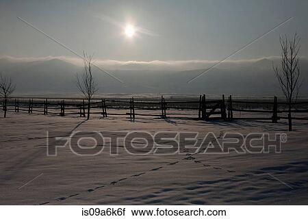 Stock Image - Sun shining over snowy field. Fotosearch