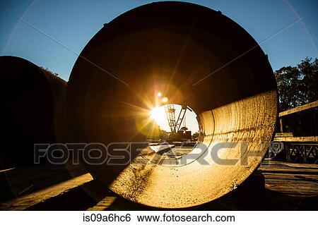 Stock Photograph - Sunrise viewed through concrete pipe. Fotosearch