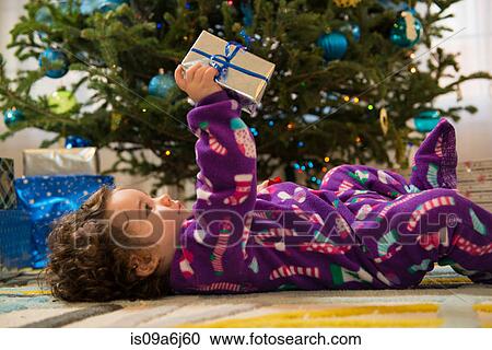 Stock Image - Toddler girl opening Christmas gifts. Fotosearch