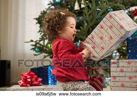 Toddler girl opening Christmas gifts View Large Photo Image Stock Photo - Toddler girl opening Christmas gifts. Fotosearch