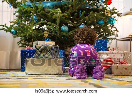 Toddler girl opening Christmas gifts View Large Photo Image Stock Photo - Toddler girl opening Christmas gifts. Fotosearch