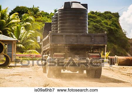 Truck carrying barrels on dirt road View Large Photo Image Stock Photo - Truck carrying barrels on dirt road. Fotosearch