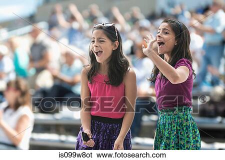 Two excited girls at a pop concert View Large Photo Image Stock Photograph - Two excited girls at a pop concert. Fotosearch